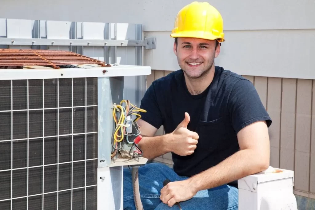 Working Class Heating and Air Conditioning Services technician giving a thumbs up while fixing, repairing, or replacing an HVAC unit to ensure efficient heating, cooling, and indoor air quality in residential and commercial properties.