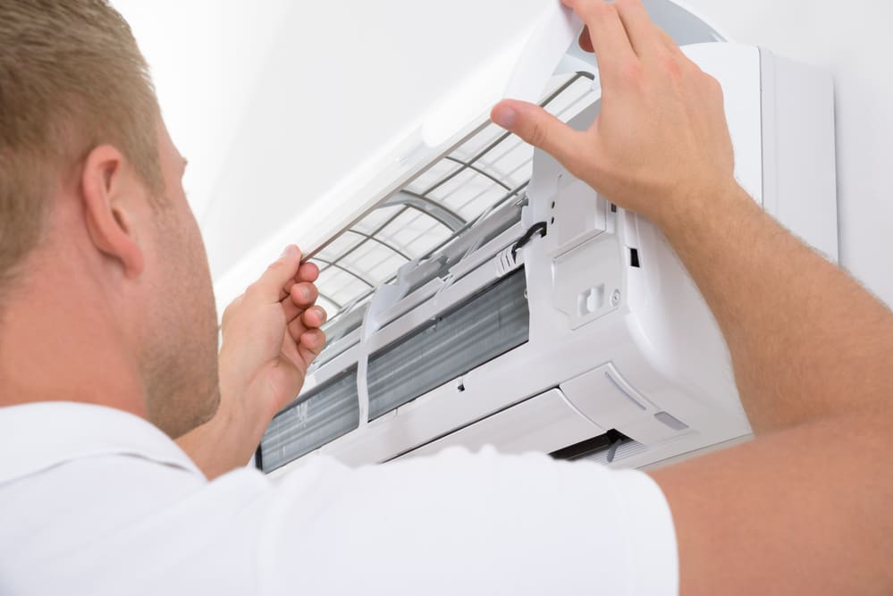 Portrait Of A Young Man Adjusting Air Conditioning System